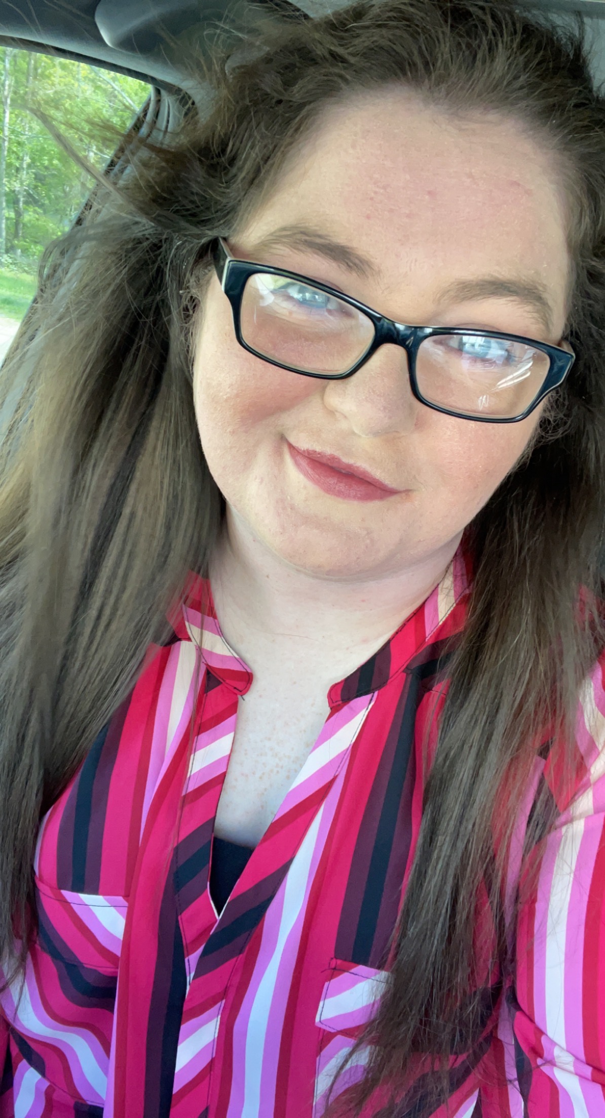Brandy in a red, pink, black, and white striped shirt wearing black rectangle glasses and medium-red lipstick